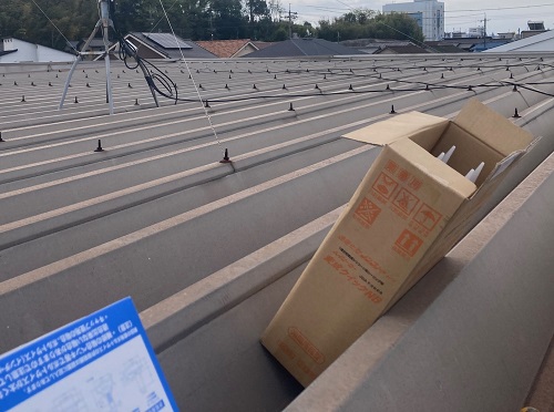 福山市で鉄骨造二階建てアパート折板屋根のボルトキャップ取付工事変成シリコンコーキング材料搬入