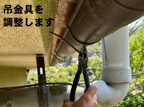 福山市にて滝のように雨水が溢れてくる雨どいの清掃と勾配調整傾いた軒樋の吊金具を調整