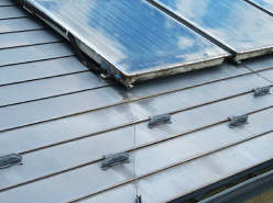 施工前の太陽光パネルが設置されたガルバリウム鋼板屋根は、色褪せと錆が見られます